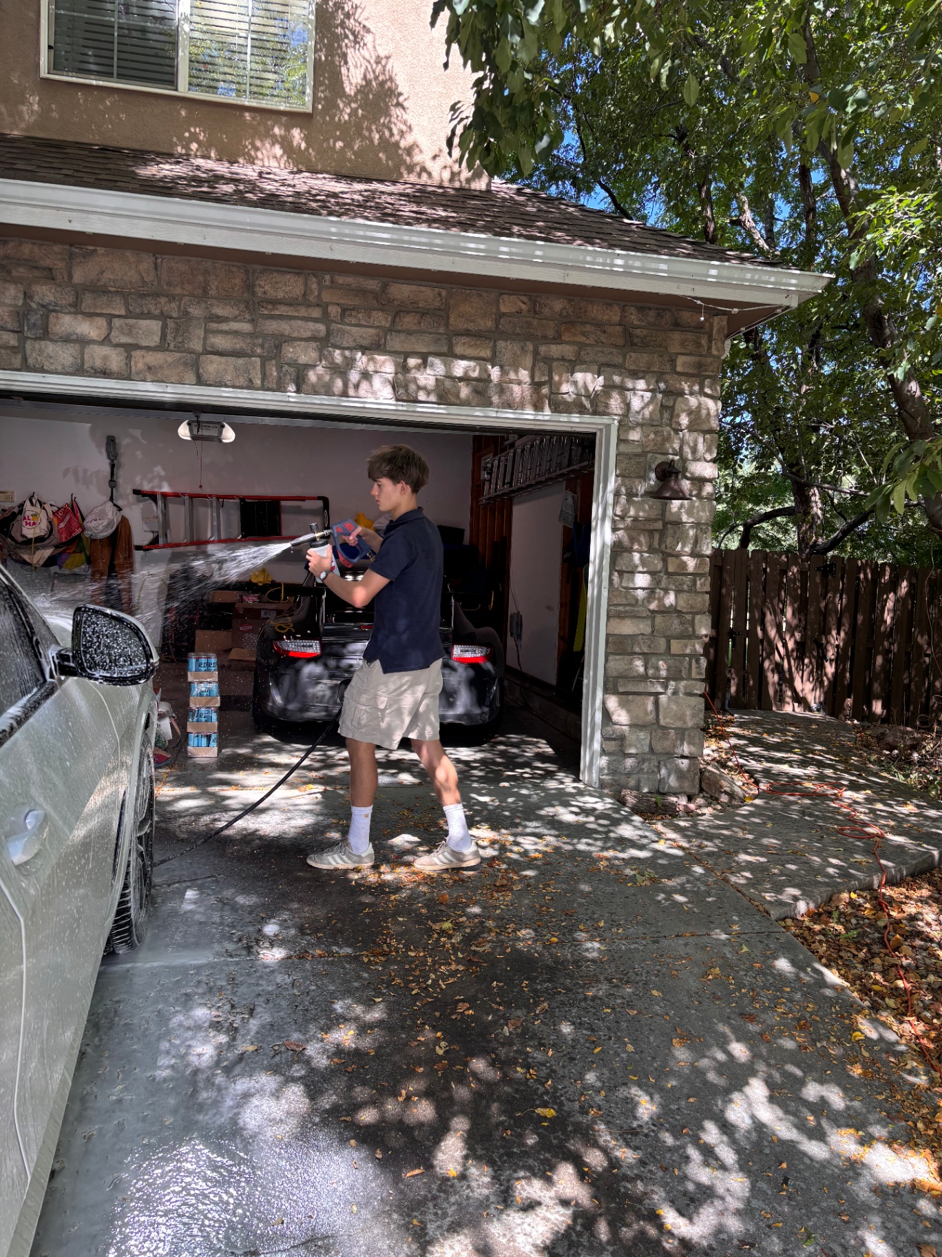 Caden washing a car in a Boulder driveway